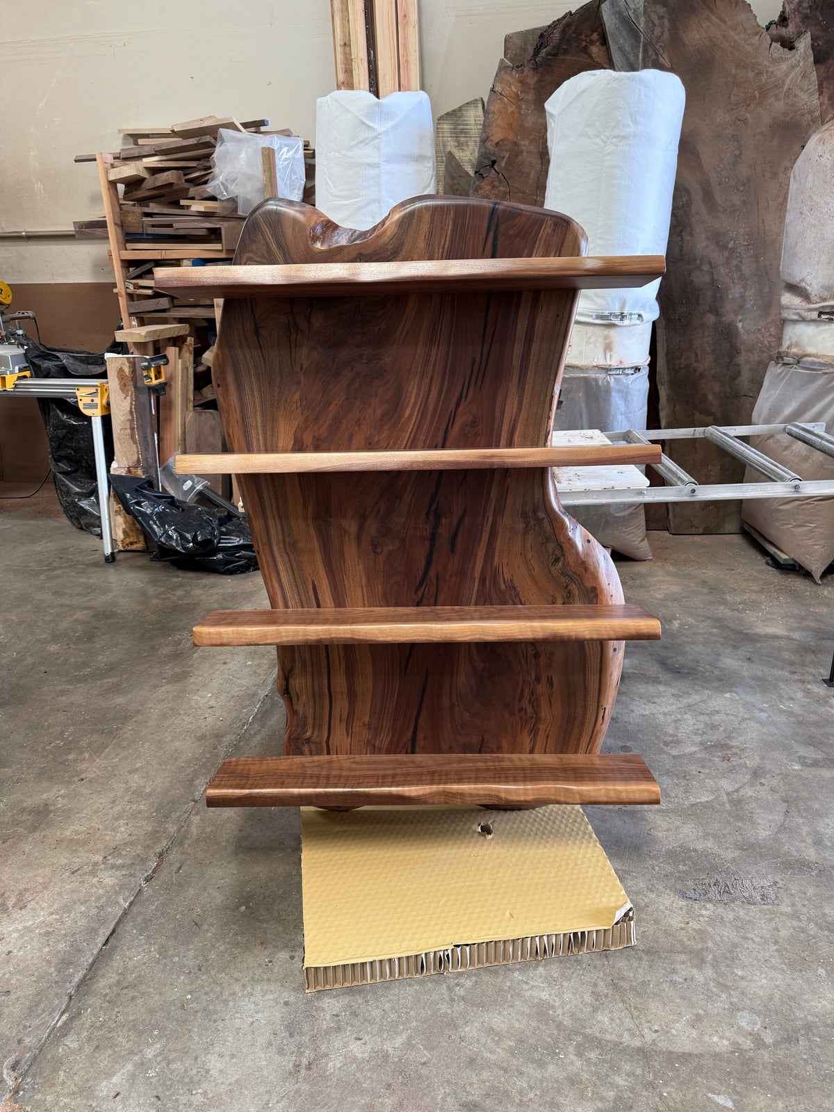 Front view of the live edge wine shelf with four wooden shelves