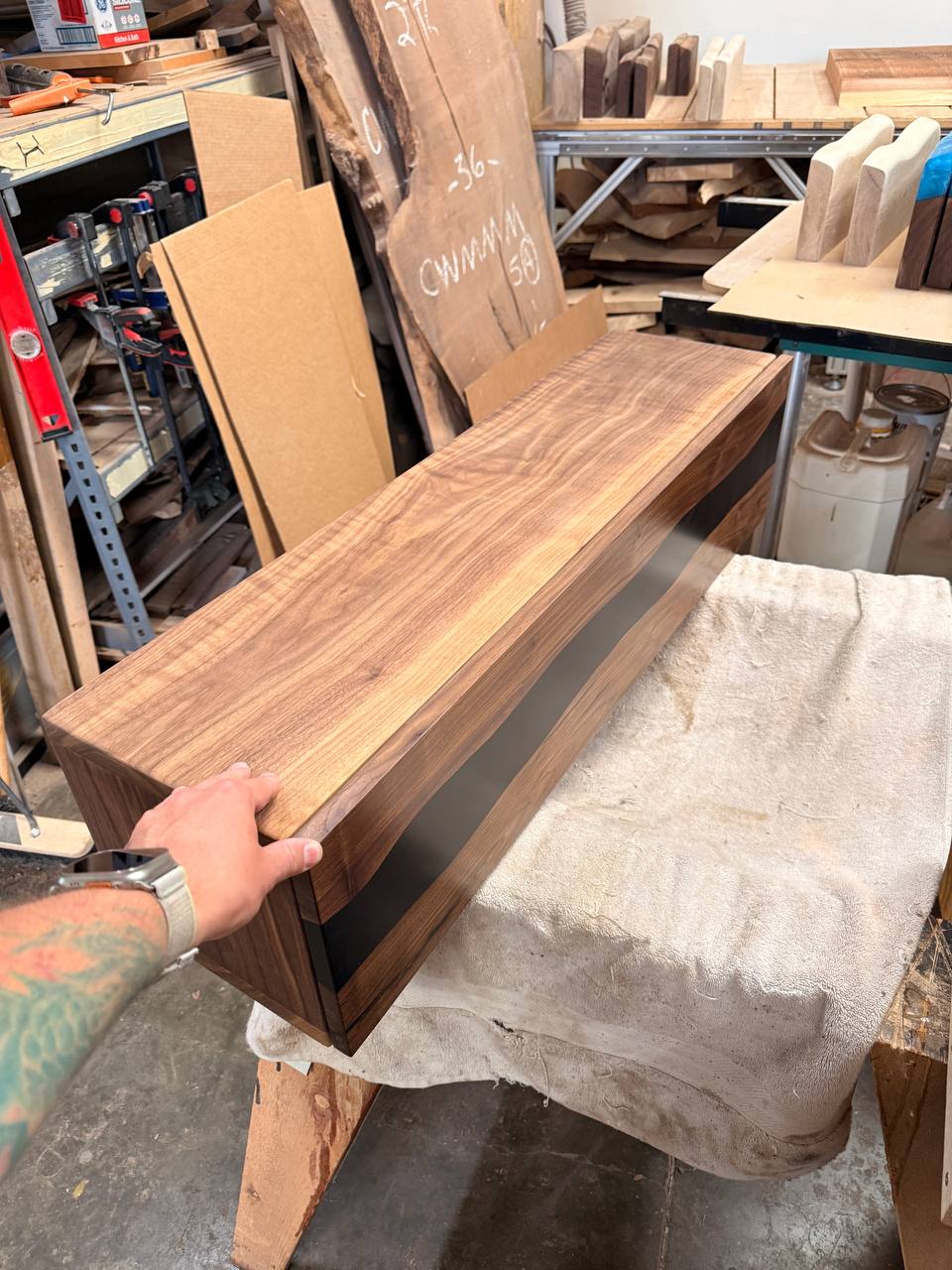 40 by 10 by 10 inch walnut and black epoxy console with closed front in the FamilyWood workshop