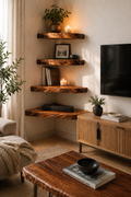 A styled living room corner with four floating rustic wood shelves mounted on a beige wall, holding books, candles, framed art, and plants. A wooden TV stand, black television, coffee table, and neutral sofa are visible in the room.