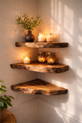 Three rustic corner floating shelves made of natural wood, styled with candles, mason jars, and a small plant in a warmly lit room corner.
